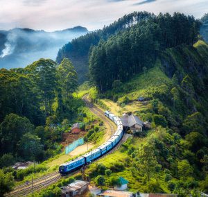 Photo of a train in misty mountains with forest in the background. Photo by: SenuScape / Pexels